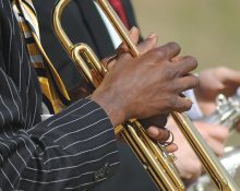 Detaljbild på två män som spelar trumpet och saxofon